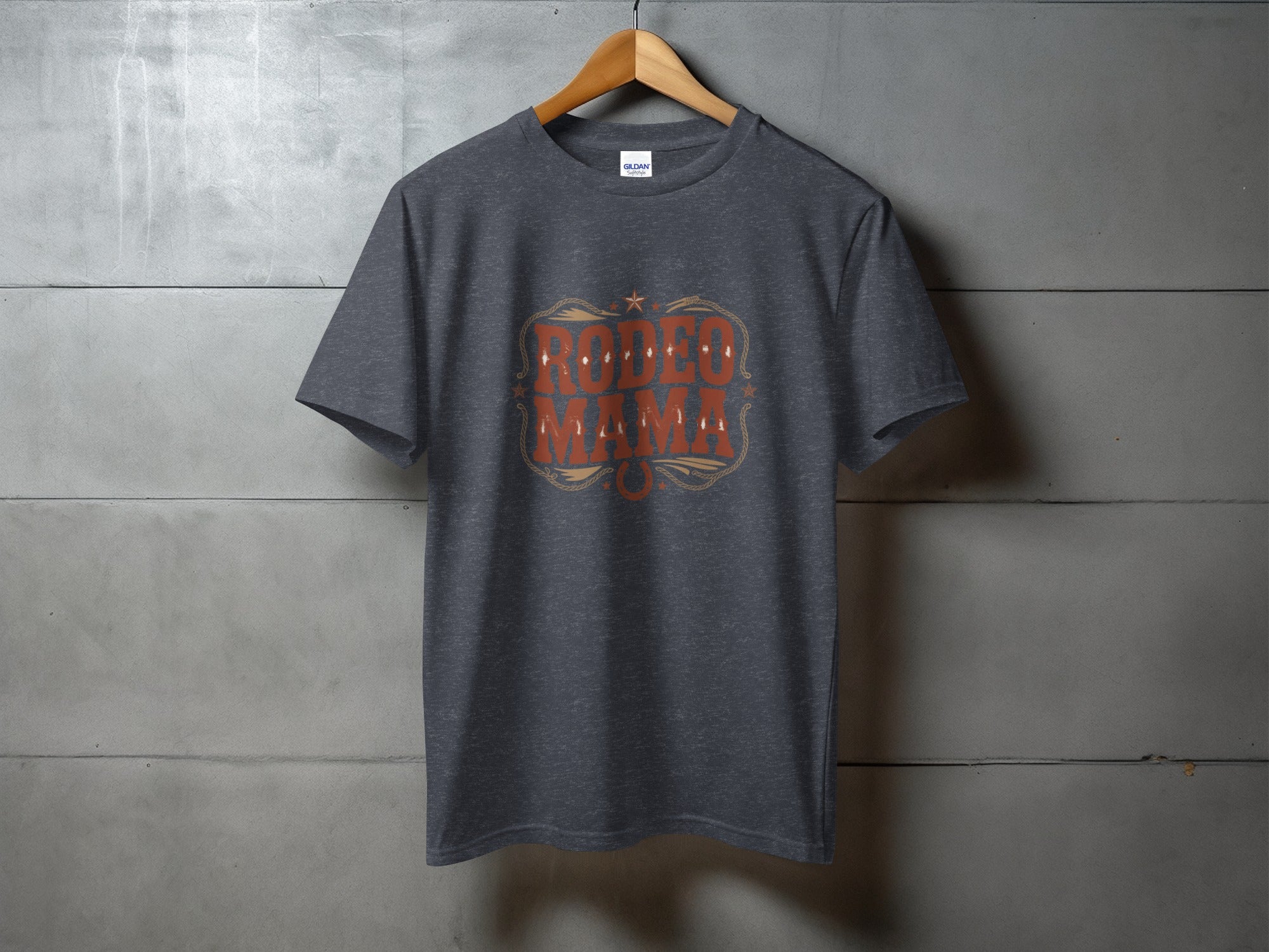 Dark grey t-shirt with "RODEO MAMA" text in orange and brown decorative font.