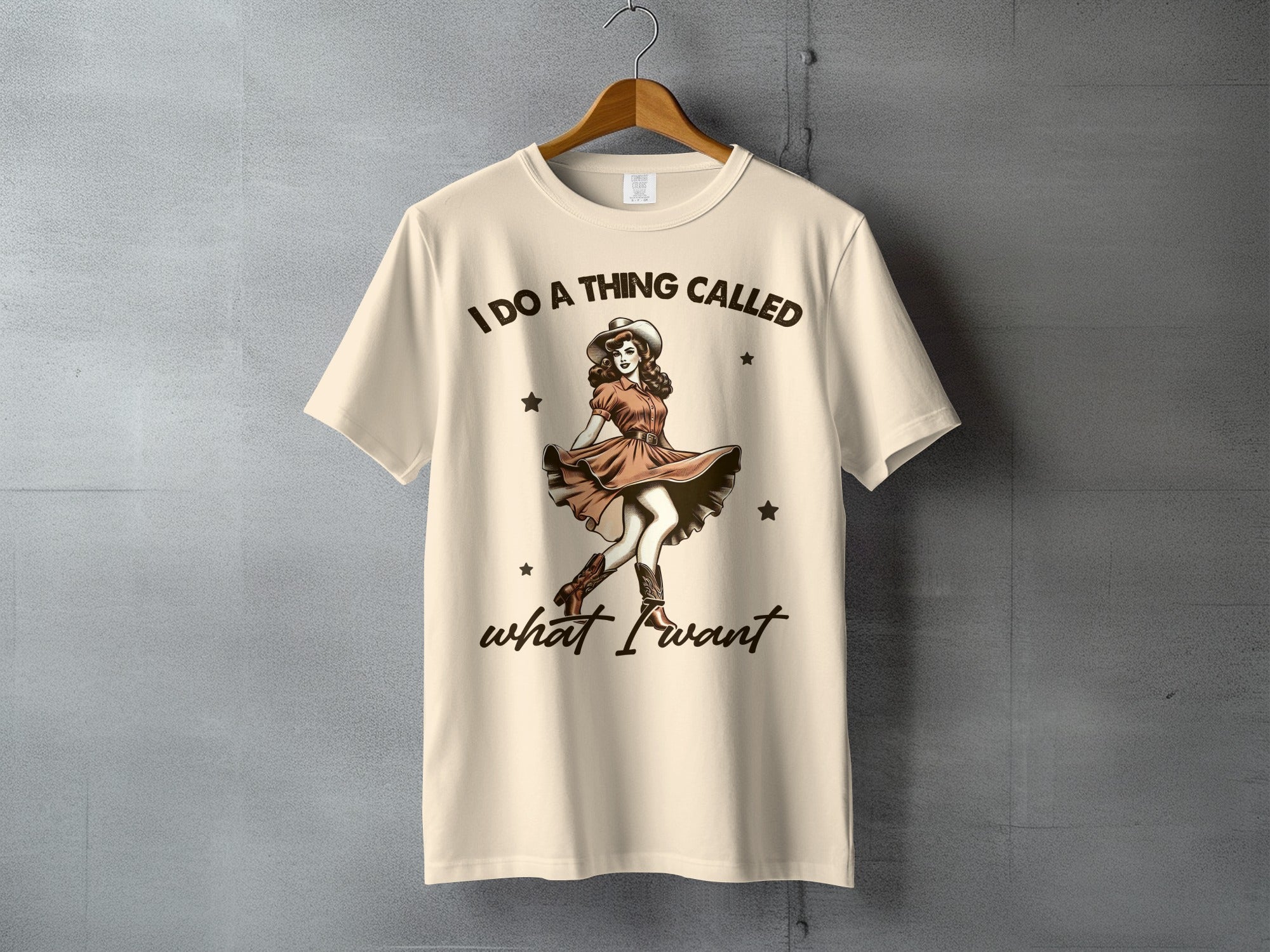 Cream t-shirt with retro cowgirl graphic and text "I DO A THING CALLED what I want".