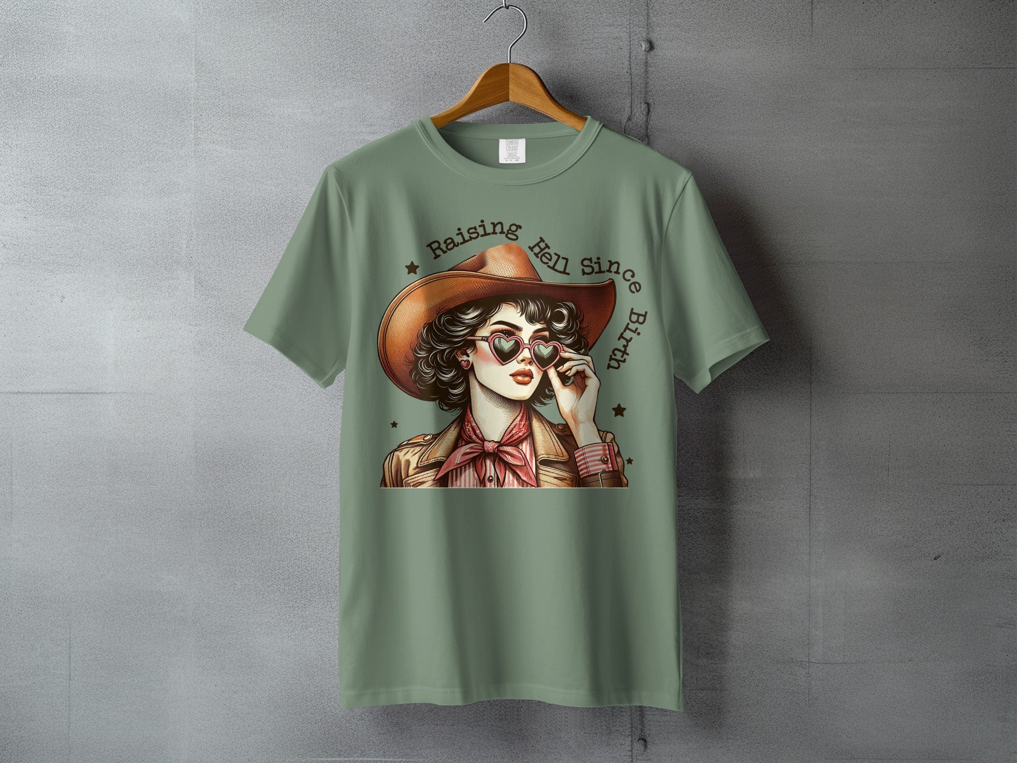 Cowgirl with heart sunglasses and text "Raising Hell Since Birth".