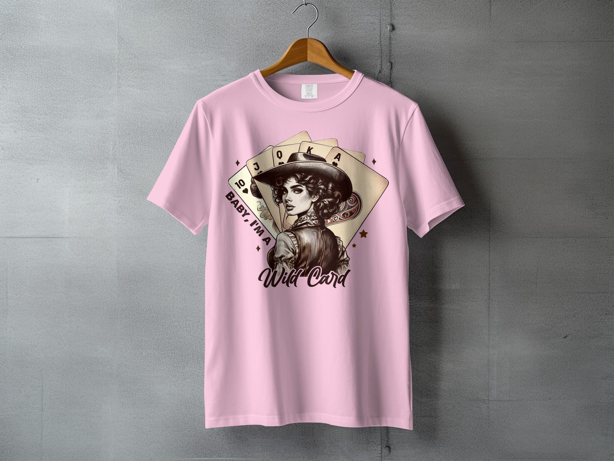Pink t-shirt with a woman in a cowboy hat and playing cards graphic.