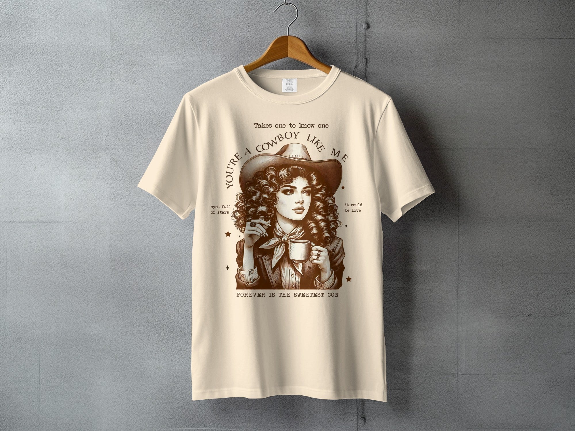 T-shirt with graphic of a woman in cowboy hat holding a mug, text reads "You're a cowboy like me".