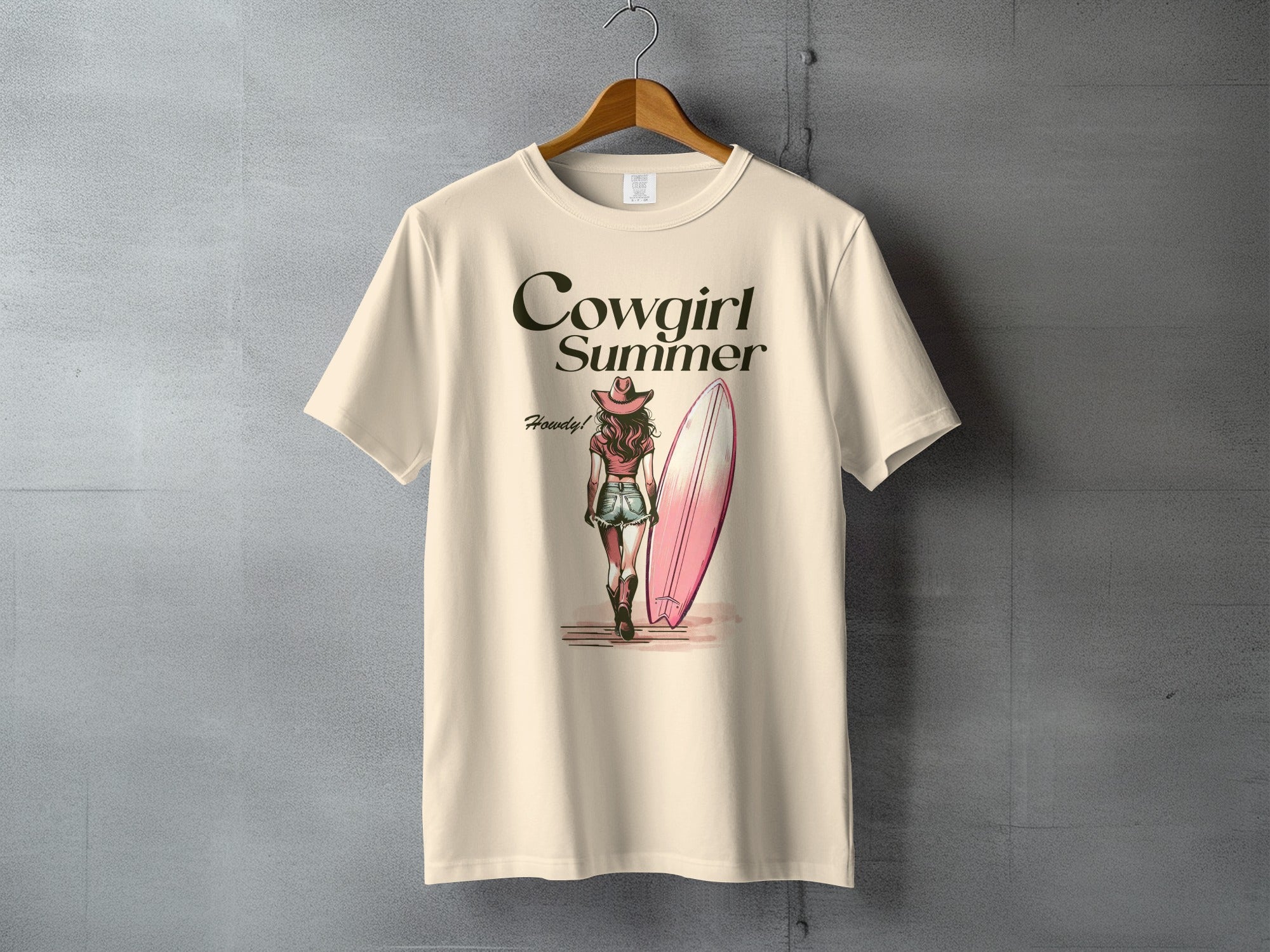 Cowgirl Summer graphic on a cream t-shirt with a surfboard.