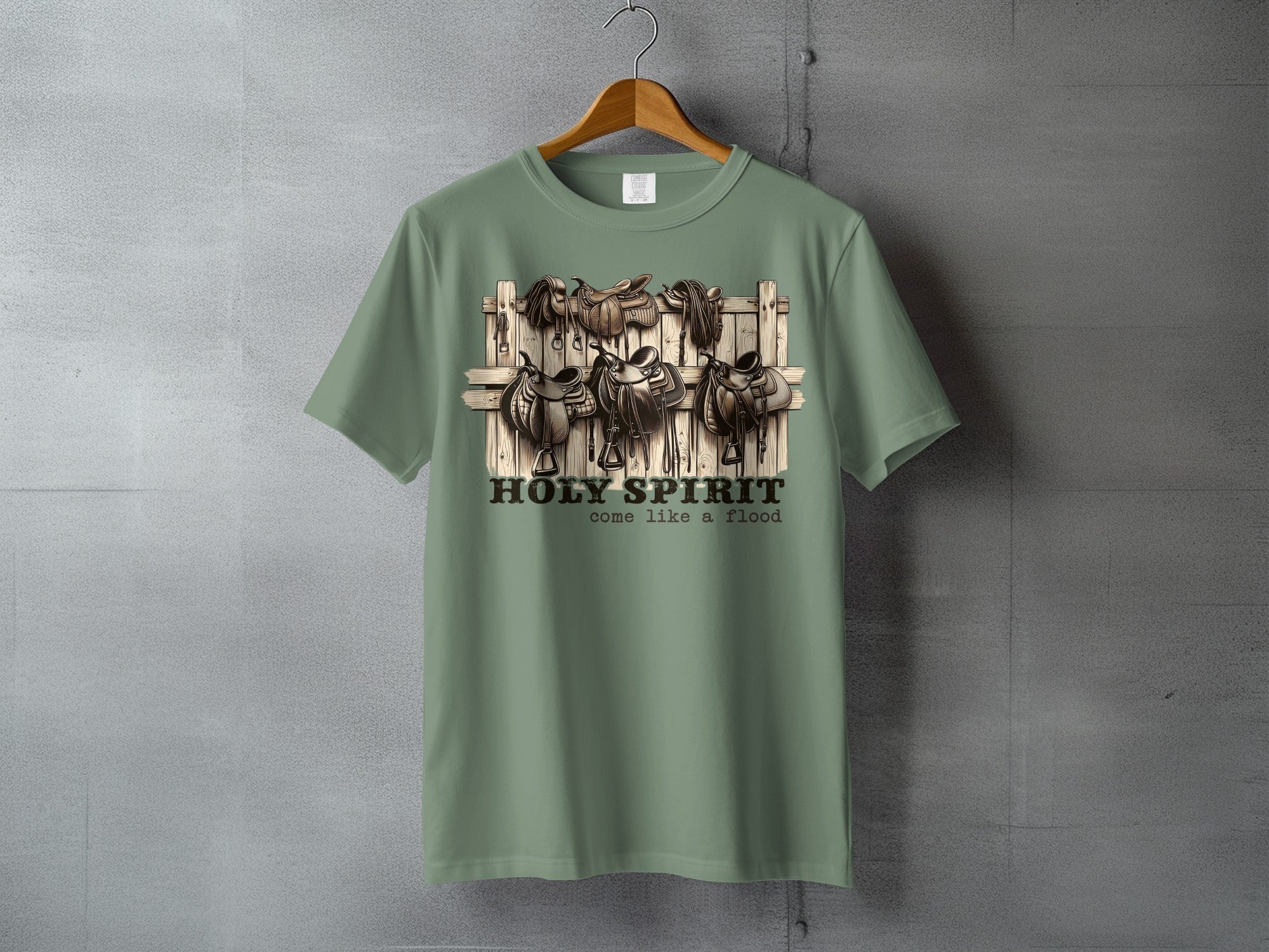 Sage green t-shirt with vintage saddles and the text "HOLY SPIRIT come like a flood".