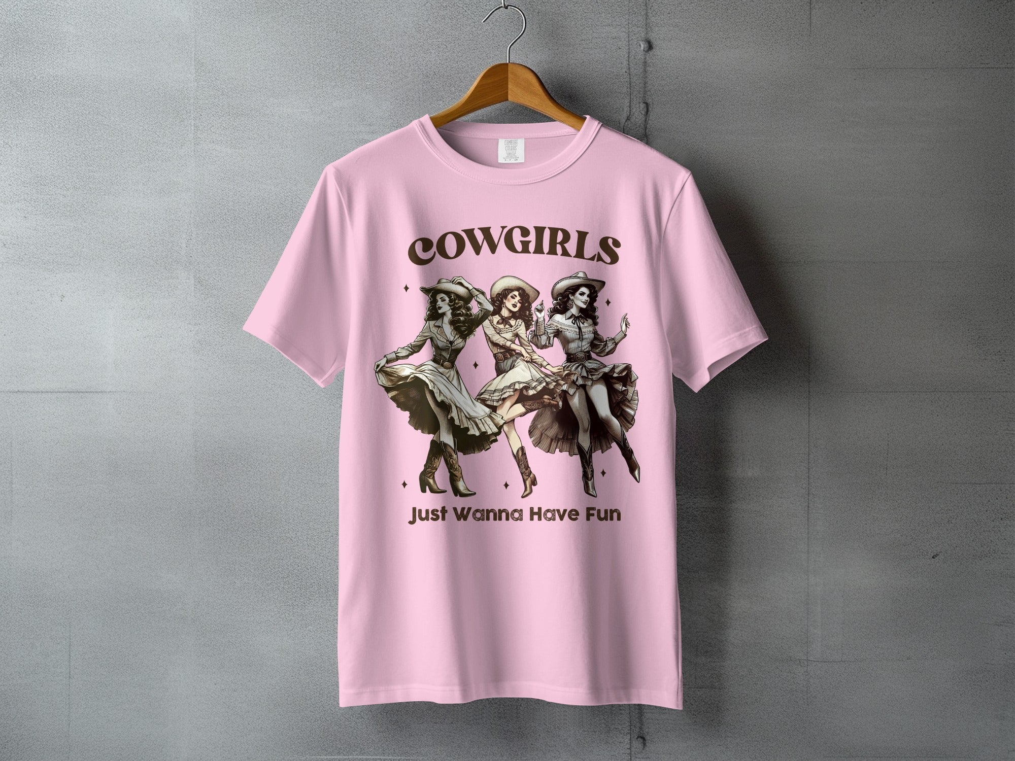 Pink t-shirt with graphic of three cowgirls dancing, text "Cowgirls Just Wanna Have Fun".